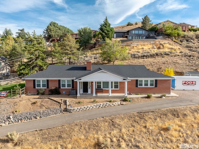 ranch-style home with central AC unit and a porch