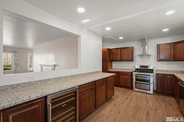 kitchen featuring wall chimney range hood, light hardwood / wood-style floors, beverage cooler, light stone countertops, and appliances with stainless steel finishes