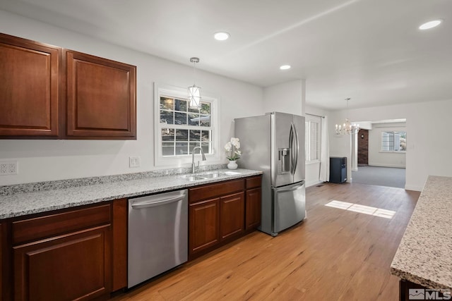 kitchen with light hardwood / wood-style floors, stainless steel appliances, plenty of natural light, and sink