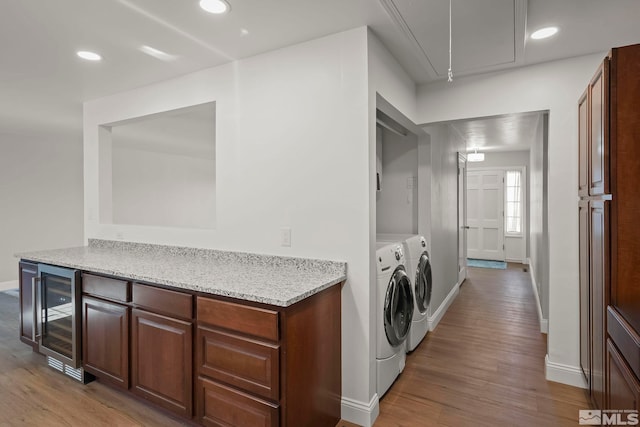 washroom featuring beverage cooler, light hardwood / wood-style floors, and washing machine and dryer