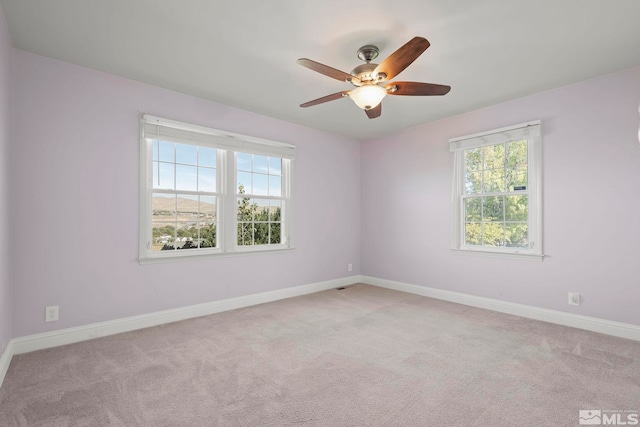 carpeted spare room with ceiling fan and a healthy amount of sunlight