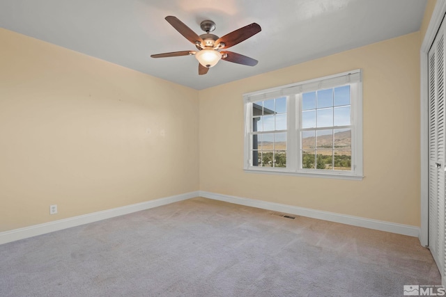 unfurnished bedroom with ceiling fan, light colored carpet, and a closet