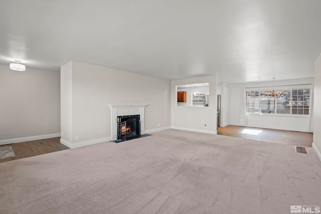 unfurnished living room with carpet floors and a chandelier