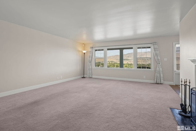 unfurnished living room featuring carpet floors and a mountain view