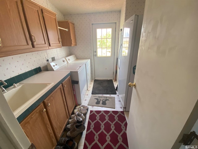 laundry room with separate washer and dryer, sink, cabinets, light tile patterned floors, and a textured ceiling