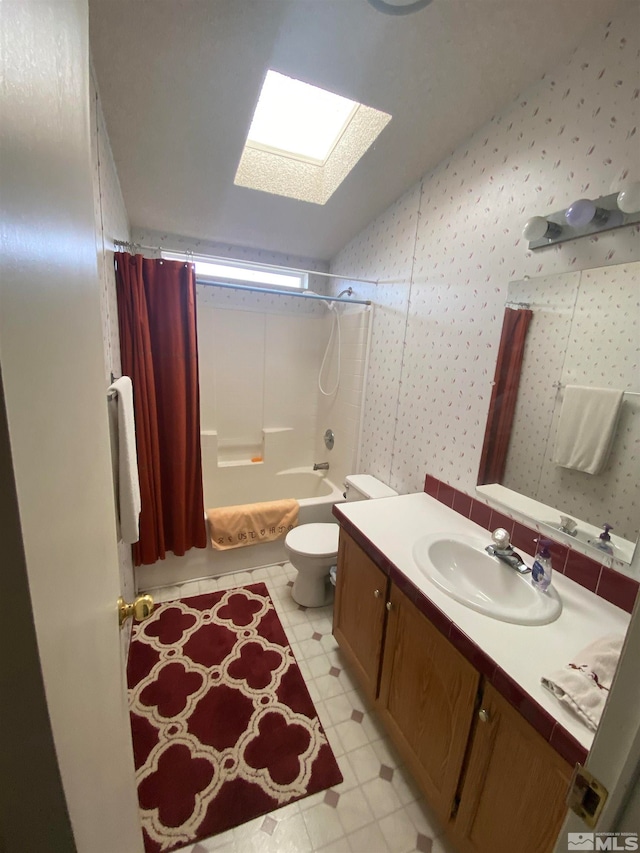 full bathroom with a skylight, toilet, shower / bath combo, and vanity