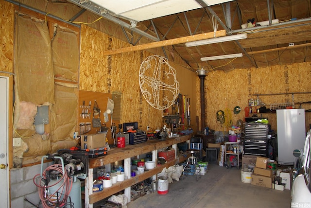 garage with white fridge and a workshop area