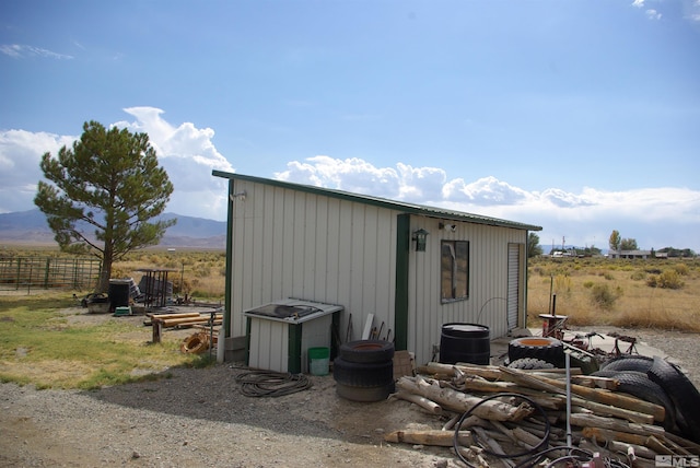 view of outdoor structure with a rural view and a mountain view