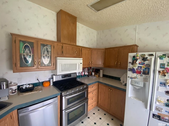 kitchen with a textured ceiling and appliances with stainless steel finishes