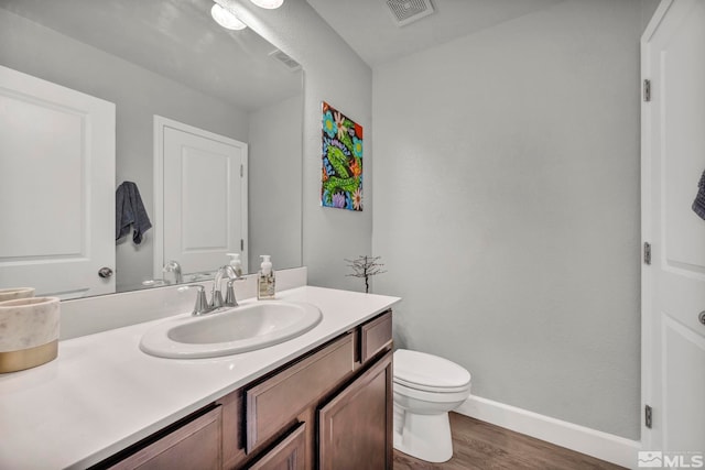 bathroom featuring hardwood / wood-style floors, vanity, and toilet