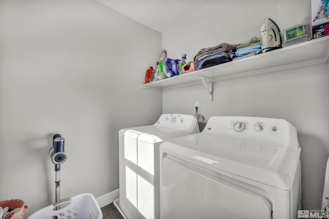 clothes washing area with hardwood / wood-style flooring and washer and dryer