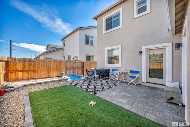 back of house with a lawn and a patio area