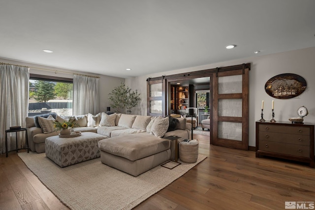 living room with hardwood / wood-style flooring, plenty of natural light, and a barn door