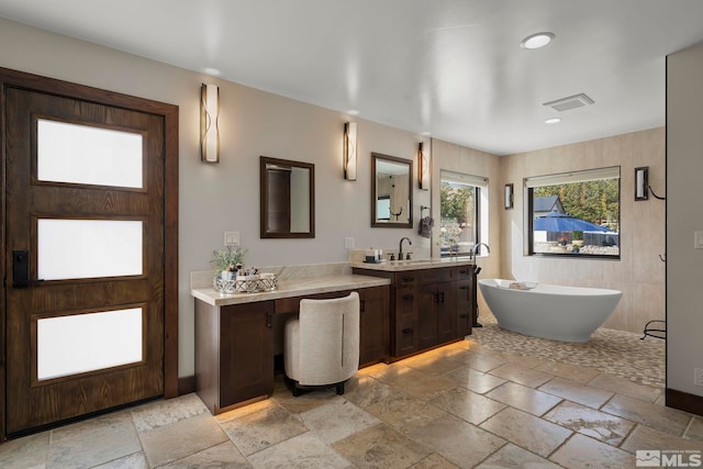 bathroom with vanity and a tub to relax in