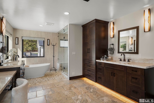 bathroom with vanity and shower with separate bathtub