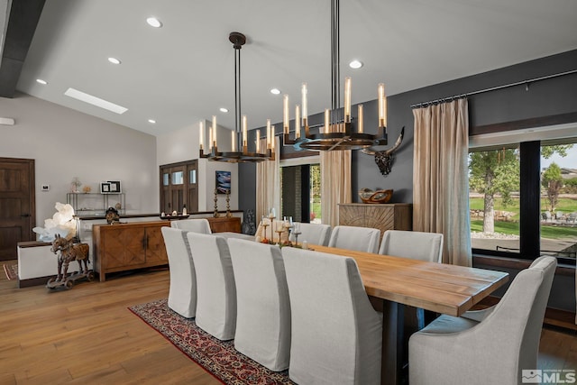 dining space featuring plenty of natural light, vaulted ceiling, and light wood-type flooring