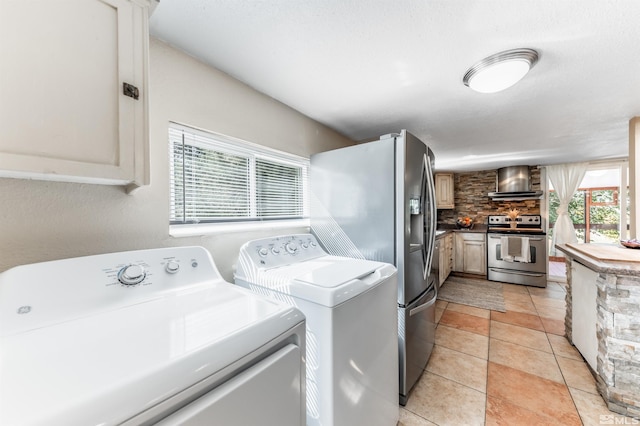 washroom with light tile patterned flooring and washing machine and dryer