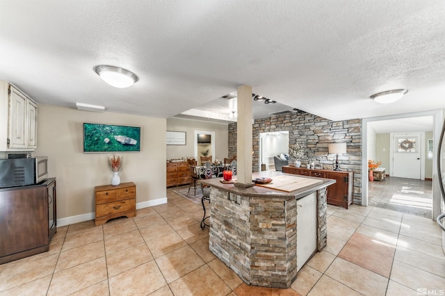 kitchen with white cabinets, a textured ceiling, and light tile patterned floors