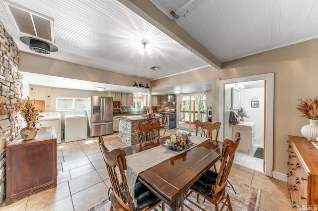 tiled dining room featuring washer and clothes dryer and wooden ceiling