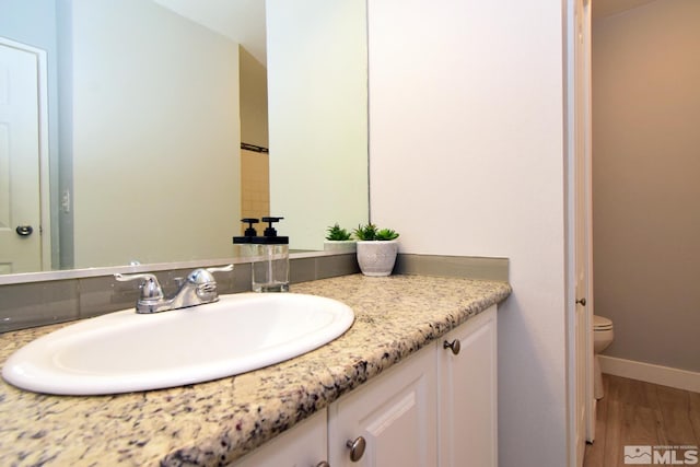 bathroom featuring vanity, toilet, and hardwood / wood-style flooring