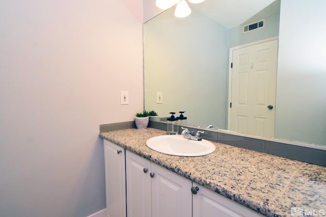 bathroom featuring vanity and lofted ceiling