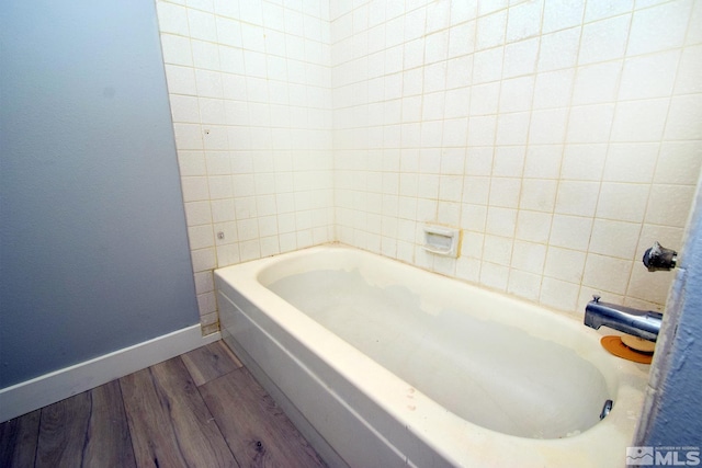 bathroom with a bathing tub and hardwood / wood-style floors