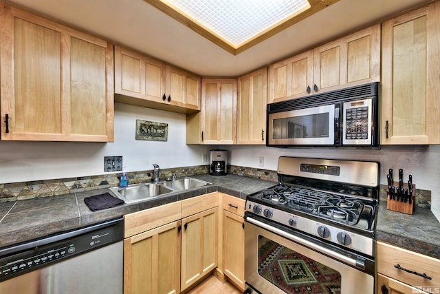 kitchen featuring stainless steel appliances, light brown cabinetry, and sink