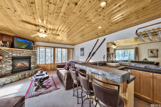 interior space featuring bar area, wood ceiling, plenty of natural light, and a fireplace