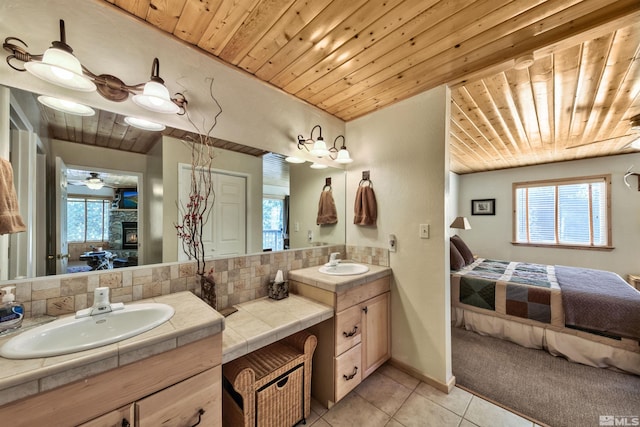 bathroom with vanity, tasteful backsplash, wooden ceiling, tile patterned floors, and a fireplace