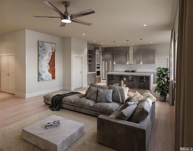 living room with light wood-type flooring, ceiling fan, and sink