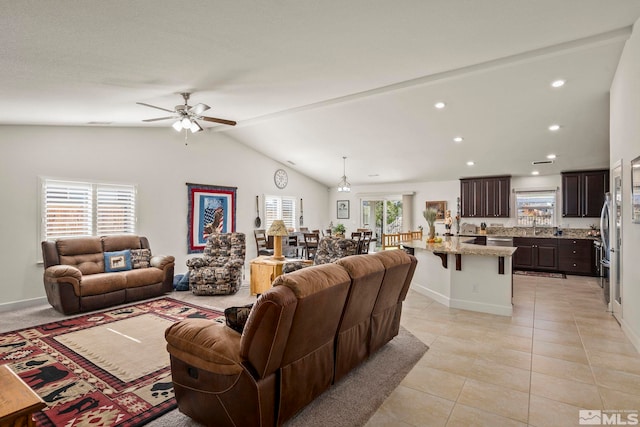 tiled living room featuring ceiling fan, plenty of natural light, and vaulted ceiling