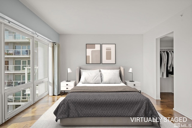 bedroom with wood-type flooring, a spacious closet, and a closet