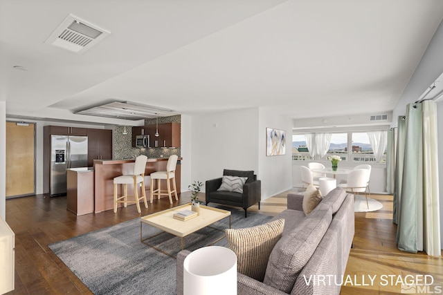 living room with visible vents and dark wood finished floors