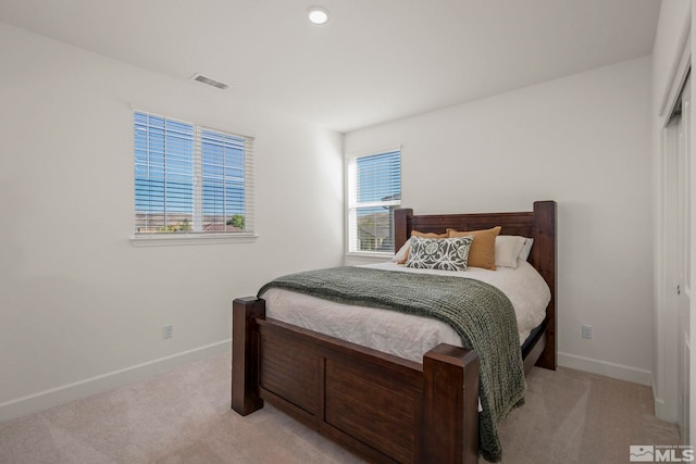 carpeted bedroom with a closet and multiple windows