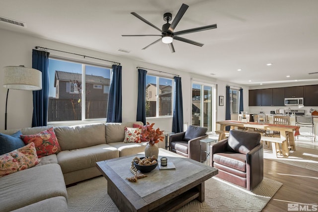 living room featuring ceiling fan and light hardwood / wood-style floors