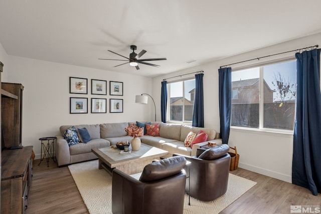 living room featuring ceiling fan and light hardwood / wood-style flooring