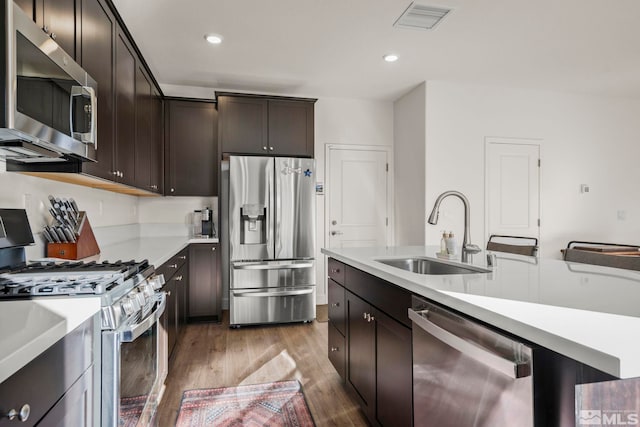 kitchen featuring light hardwood / wood-style flooring, appliances with stainless steel finishes, sink, and dark brown cabinets