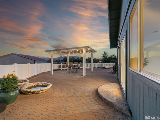 patio terrace at dusk featuring a pergola