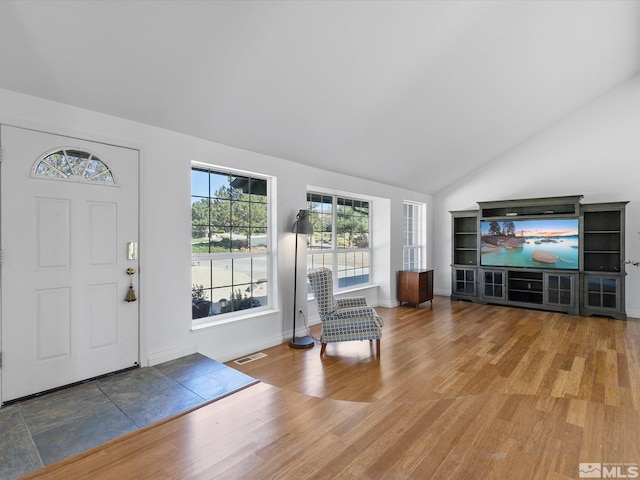 entrance foyer with hardwood / wood-style floors and vaulted ceiling