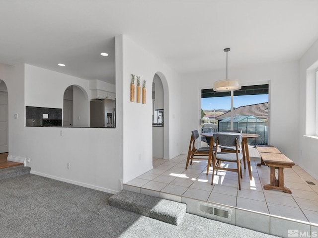 dining space featuring light carpet