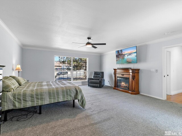 carpeted bedroom with ornamental molding and ceiling fan