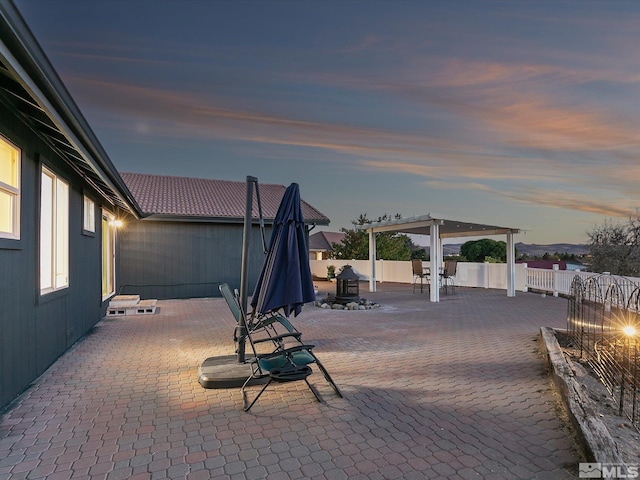 patio terrace at dusk featuring a pergola