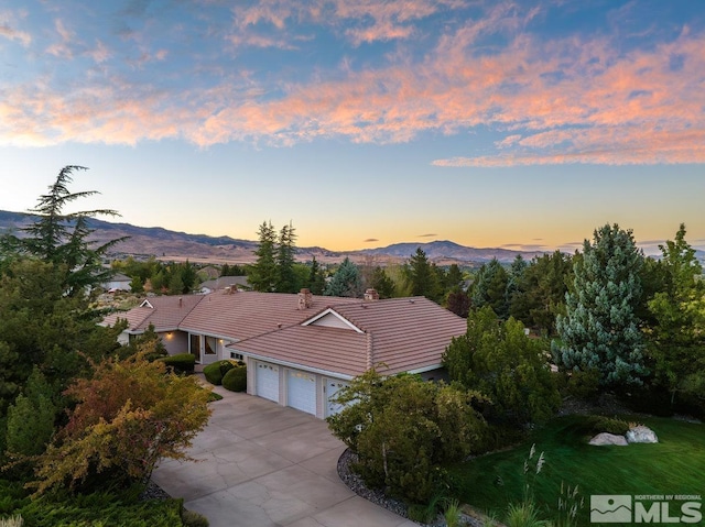 aerial view at dusk featuring a mountain view