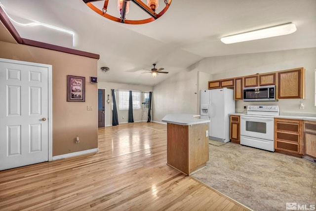 kitchen featuring vaulted ceiling, ceiling fan with notable chandelier, light hardwood / wood-style floors, a center island, and white appliances