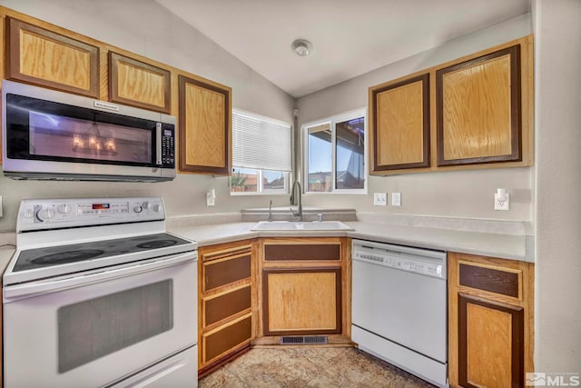 kitchen with white appliances, lofted ceiling, and sink