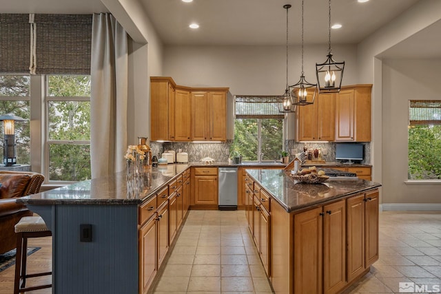 kitchen with a wealth of natural light, kitchen peninsula, dark stone countertops, and tasteful backsplash