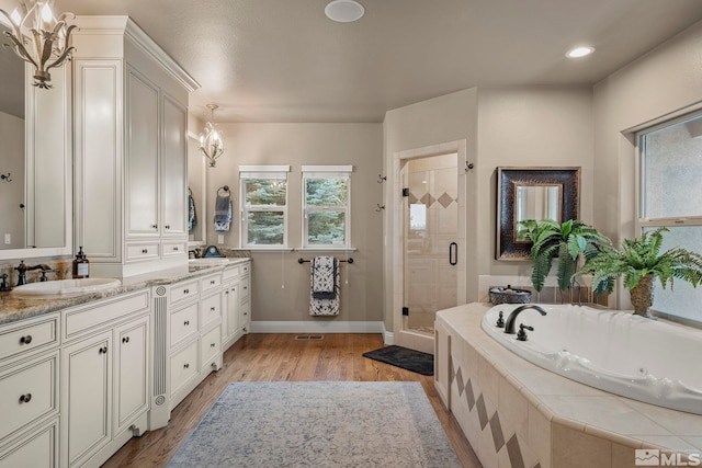 bathroom featuring vanity, a notable chandelier, hardwood / wood-style floors, and shower with separate bathtub