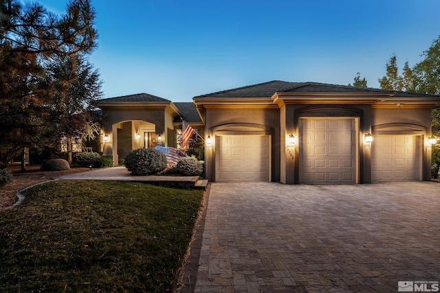 prairie-style home featuring a yard and a garage