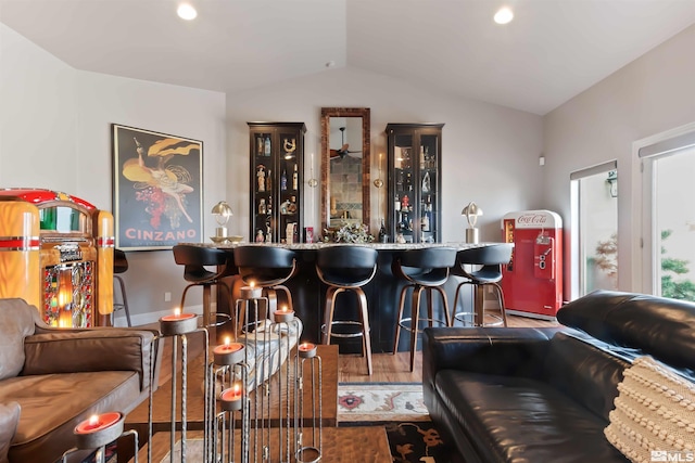 bar featuring lofted ceiling and wood-type flooring