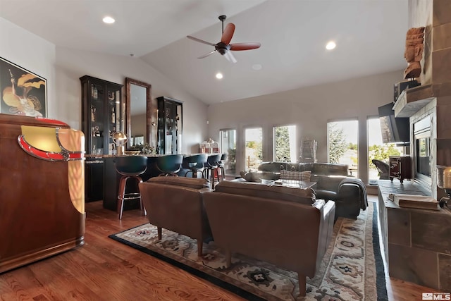 living room with dark wood-type flooring, ceiling fan, and high vaulted ceiling